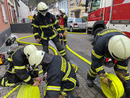 Sechs Feuerwehrleute bringen Schläuche aus.