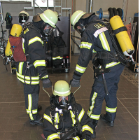 Zwei Feuerwehrmänner üben, einen Kollegen zu retten.