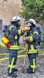 Zwei Personen in voller Feuerwehrausrüstung