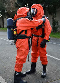 Zwei CBRN-Erkunder überprüfen sich gegenseitig ihre Schutzausrüstung.