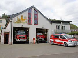 Das Gerätehaus der Freiwilligen Feuerwehr Biewer. Zwei Feuerwehrfarzeuge stehen im Gerätehaus, eines davor.