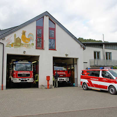 Das Gerätehaus der Freiwilligen Feuerwehr Biewer. Zwei Feuerwehrfarzeuge stehen im Gerätehaus, eines davor.