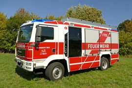 Das Löschgruppenfahrzeug LF 20 KatS der Freiwilligen Feuerwehr Irsch steht auf einer Wiese.