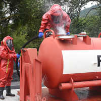 Feuerwehrleute prüfen in schwerer Schutzkleidung, ob durch chemische Stoffe Gefahr für Menschen und Umwelt besteht.